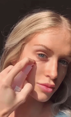 a gif of someone using the dew drops and rubbing it in their skin