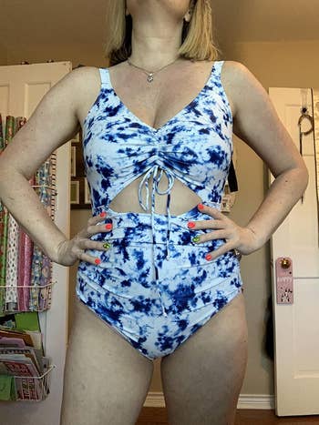 reviewer showing the white and blue swimsuit