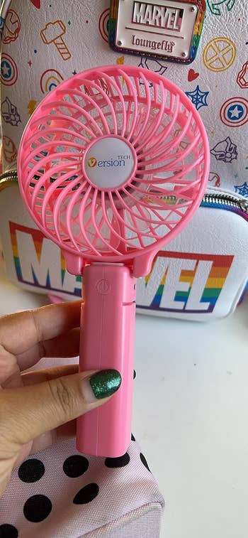 hand holding the fan with the handle extended