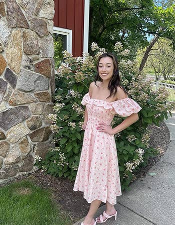 reviewer wearing pink floral dress off the shoulders with strappy heels