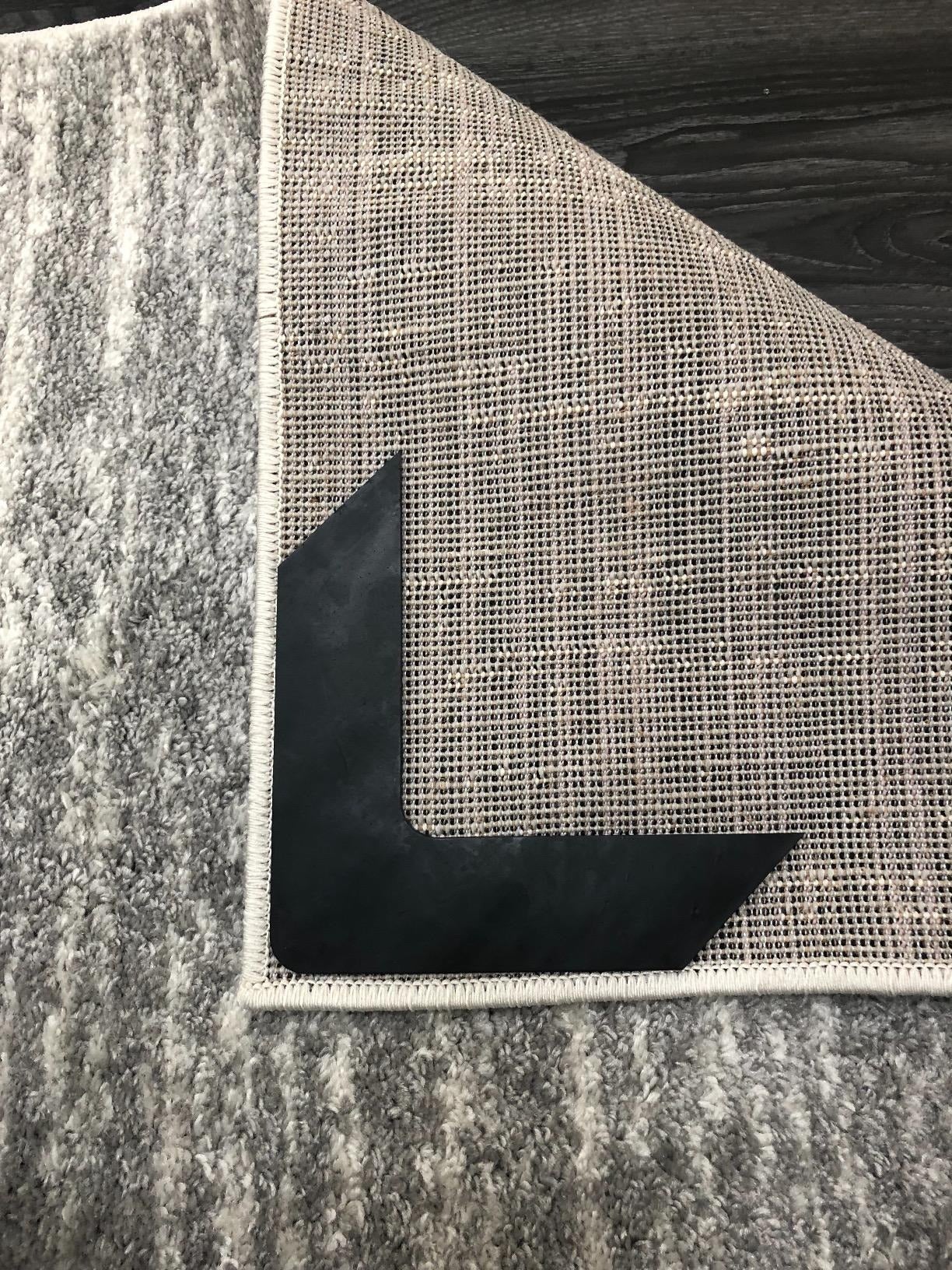 reviewer image of a rug gripper on the underside of a rug