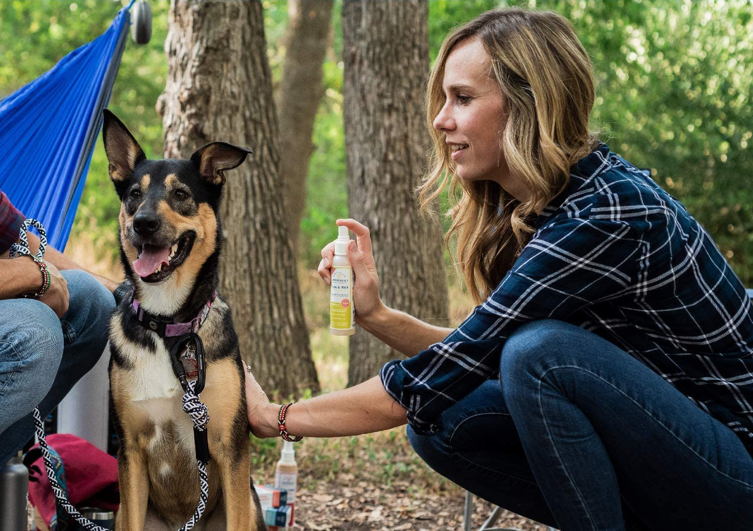 Model sprays the 4 oz bottle on a dog outside