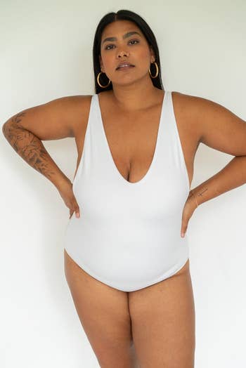 model wears a white sleeveless V-neck one-piece swimsuit 