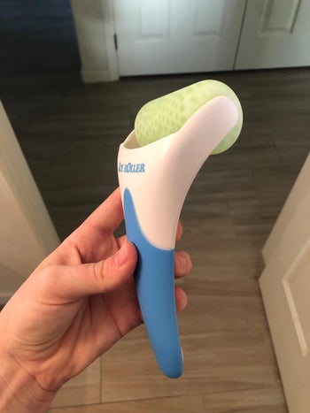 Reviewer holding blue ice roller 