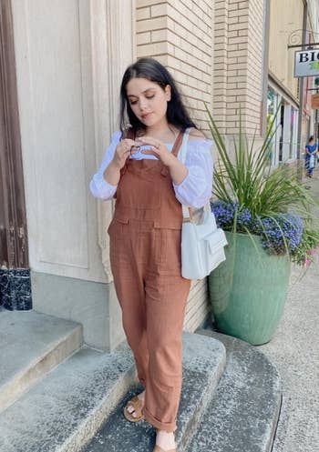 reviewer in brown overalls and white blouse