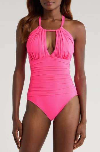 Model wearing a agleam pinkish 1 portion swimsuit