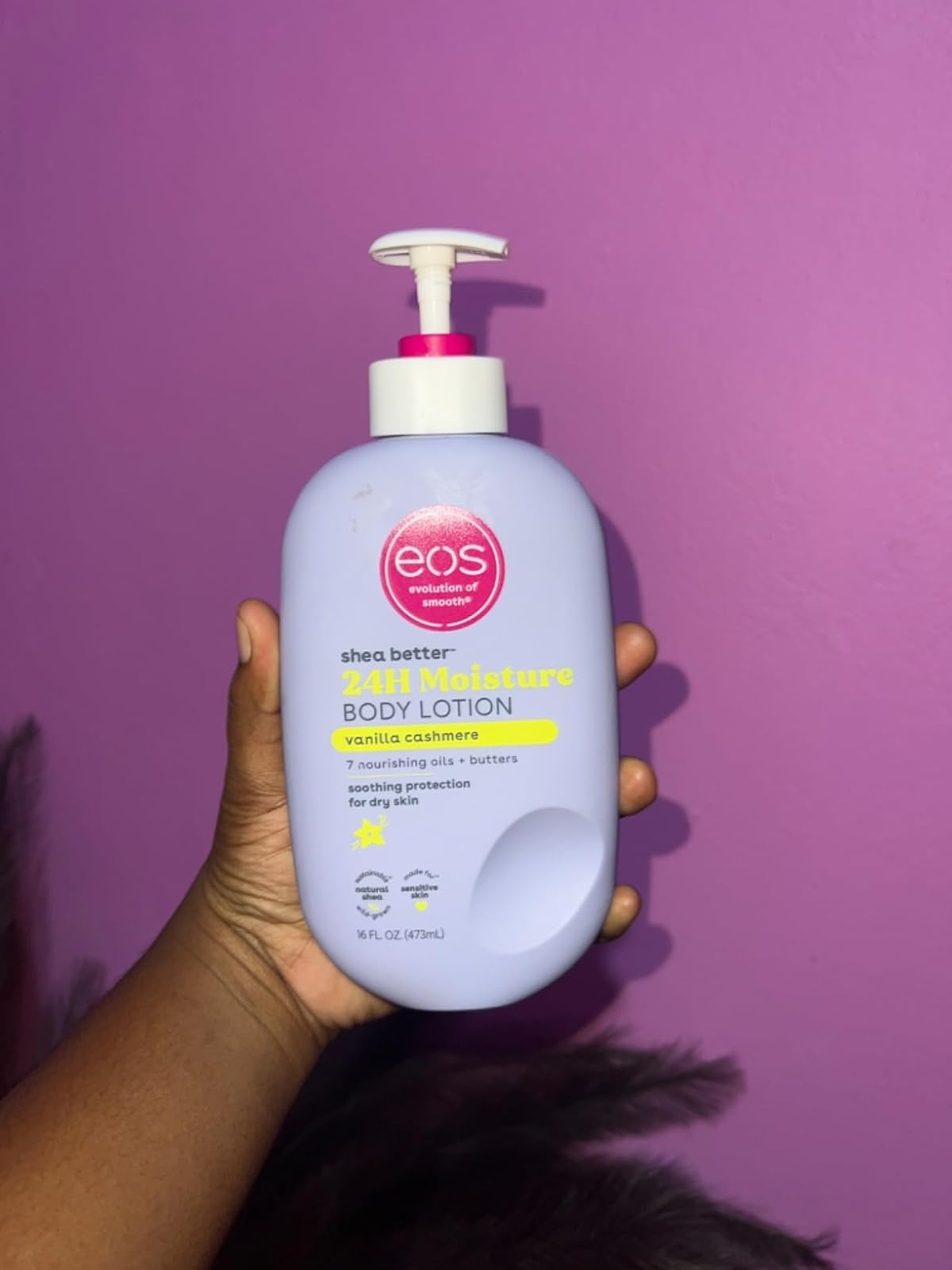 Tangan memegang sebotol EOS Body Lotion dengan aroma Vanilla Cashmere