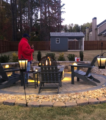 a firepit with the two bluetooth speakers hanging and glowing
