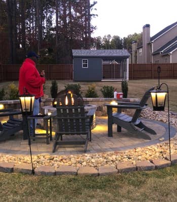 a firepit with the two bluetooth speakers hanging and glowing
