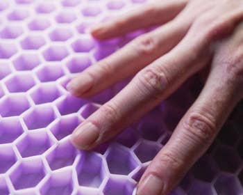 model's hand on the purple flex grid pillow design