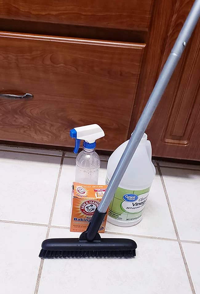 a reviewer photo of the broom next to some cleaning supplies 