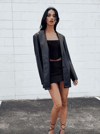 a gif of a model twirling around in the faux leather blazer 