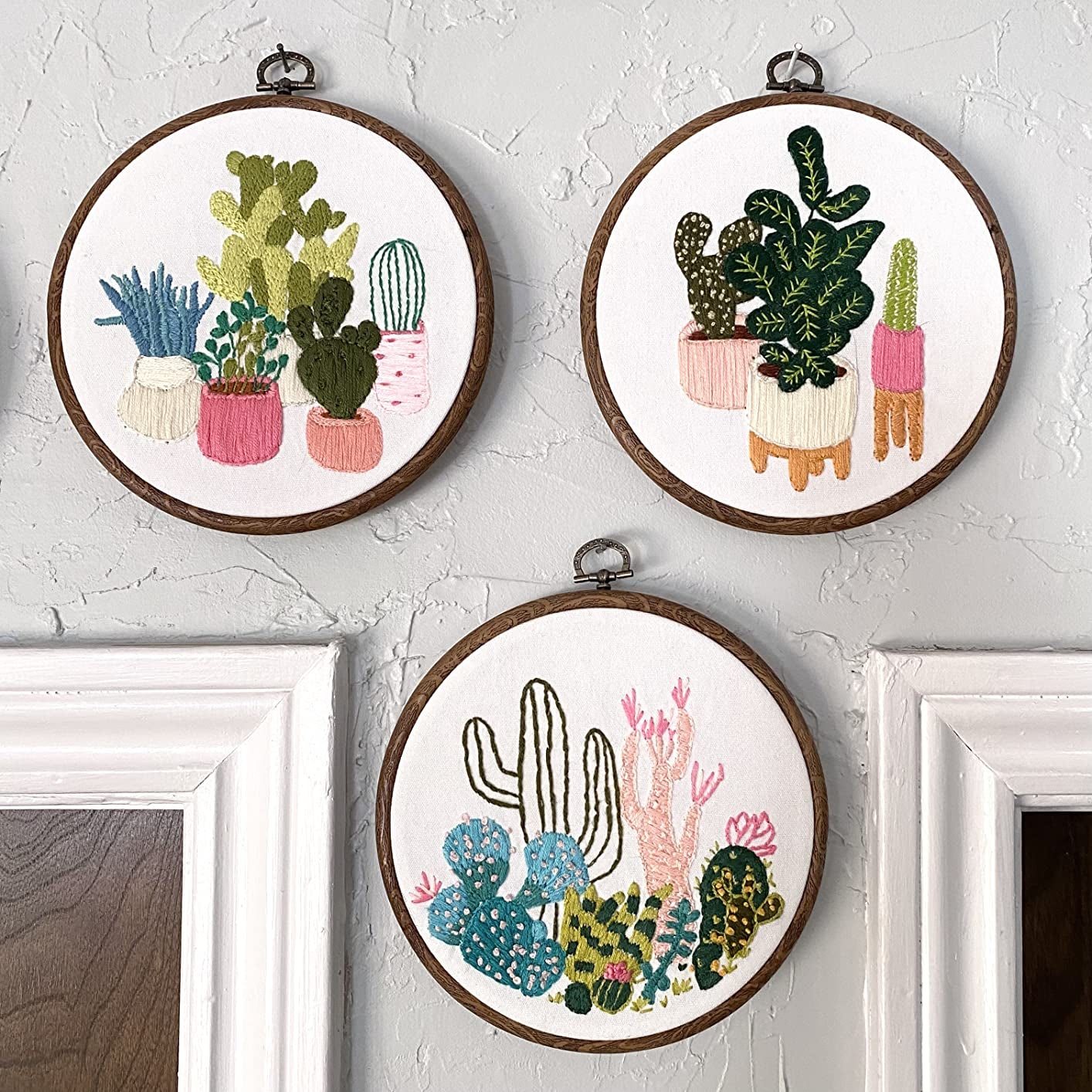 Reviewer's three embroidery projects hanging on a wall