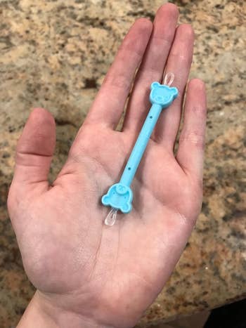 reviewer holding the small blue cleaner in their palm