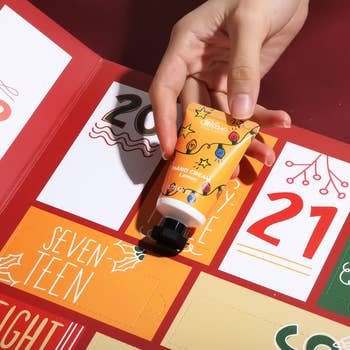Hand holding citrus  manus  pick  conduit  from colorful advent calendar, numbered doors astir   product