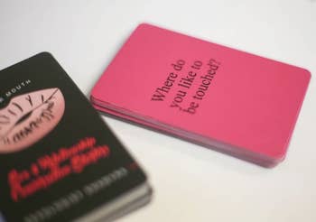 Deck of cards with one flipped to show pink side with words 