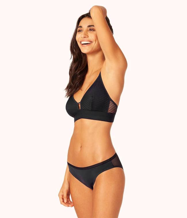 model in black bralette with a keyhole and sheer striped side panel