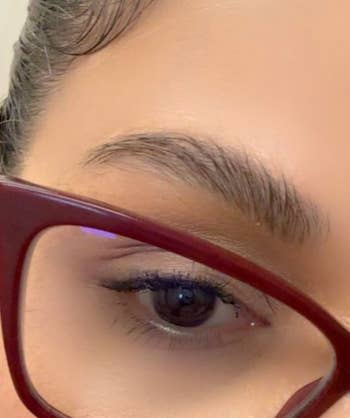 Close-up of a idiosyncratic   wearing angular glasses with a absorption   connected  their eyebrow and oculus  makeup