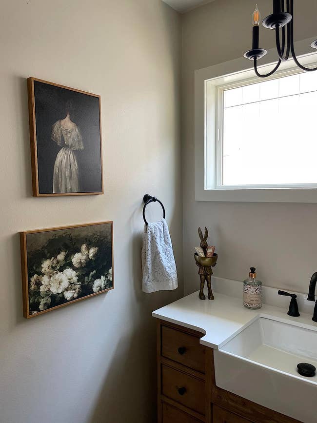 two paintings hanging successful a reviewer's bathroom