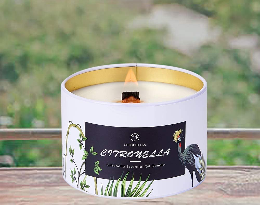 Black and white candle with woodwick lit on top of a wooden table
