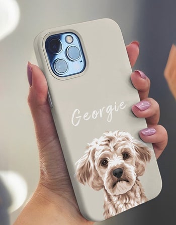 model holding phone in a tan case with a golden doodle on it that says 