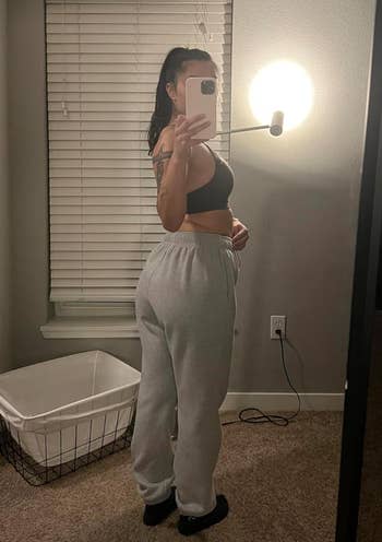 reviewer showing off back of grey sweatpants