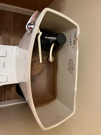 before photo of a toilet tank with brown stains on the sides