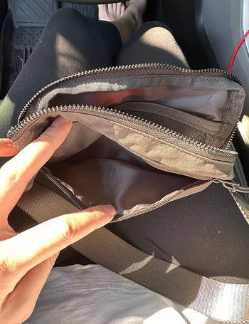 Reviewer opening the fanny pack to show pockets on the inside 