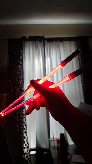 reviewer holding glowing red chopsticks