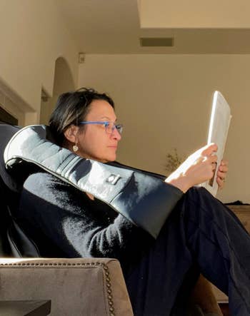 reviewer lounging in a chair, reading a tablet, with sunlight streaming in