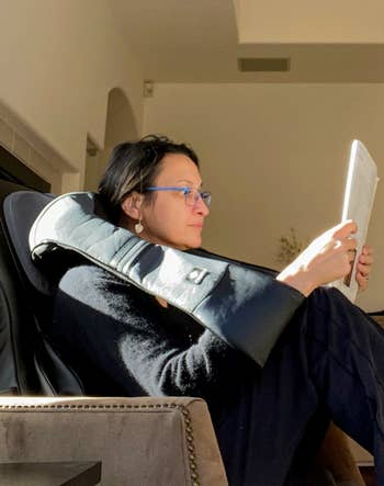 reviewer lounging in a chair, reading a tablet, with sunlight streaming in