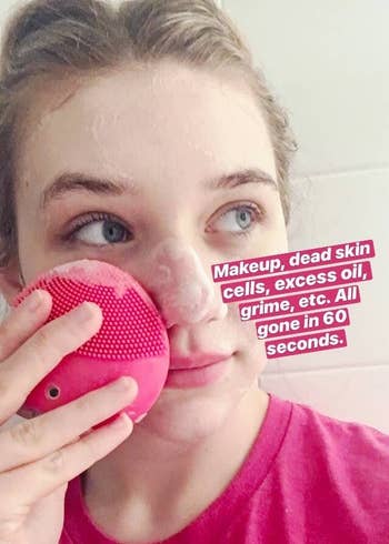 BuzzFeed editor using the pink sonic cleansing brush on their face with text that reads 