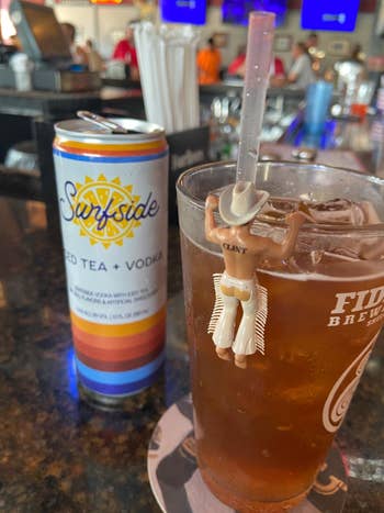 Can of Surfside iced beverage  + vodka beside a solid  with a cowboy-themed portion  marker astatine  a bar