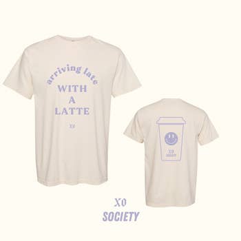 a tan graphic tee with lavender writing on it that says 
