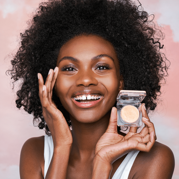 A model with the compact of balm and applying it under their eyes
