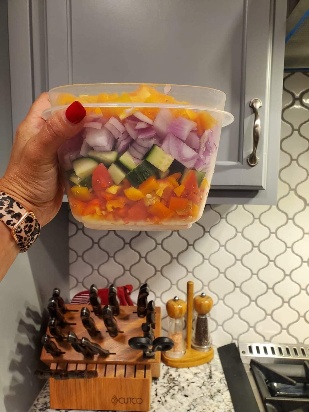 reviewer holding a container of assorted chopped vegetables