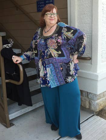 reviewer photo wearing turquoise palazzo pants in front of the stairs 