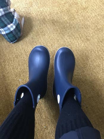 reviewer POV photo wearing navy blue Crocs boots