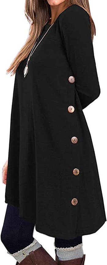 model wearing a black tunic with buttons on the sides