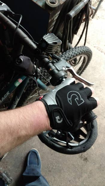 reviewer photo wearing half-finger bike gloves on handlebar