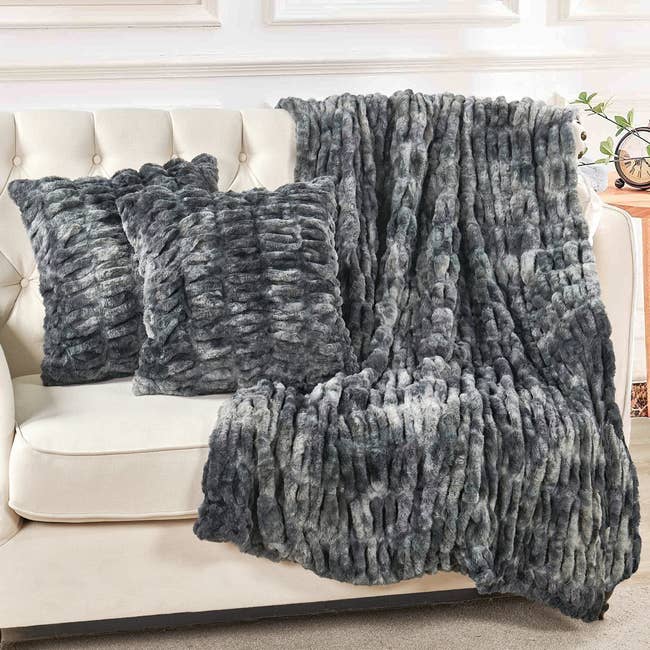 Textured faux fur throw blanket and pillows on a couch, adding a cozy touch to home decor