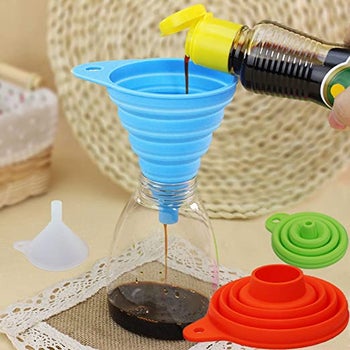 a blue silicone funnel being used to funnel liquid from one container to another