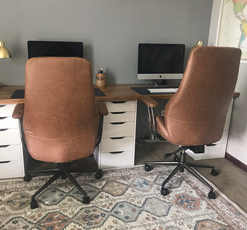 a back view of two of the chairs in front of a double desk 