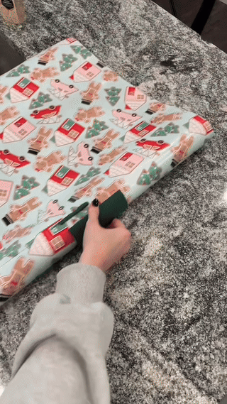 Wrapping a acquisition  with holiday-themed insubstantial  featuring festive images connected  a granite countertop