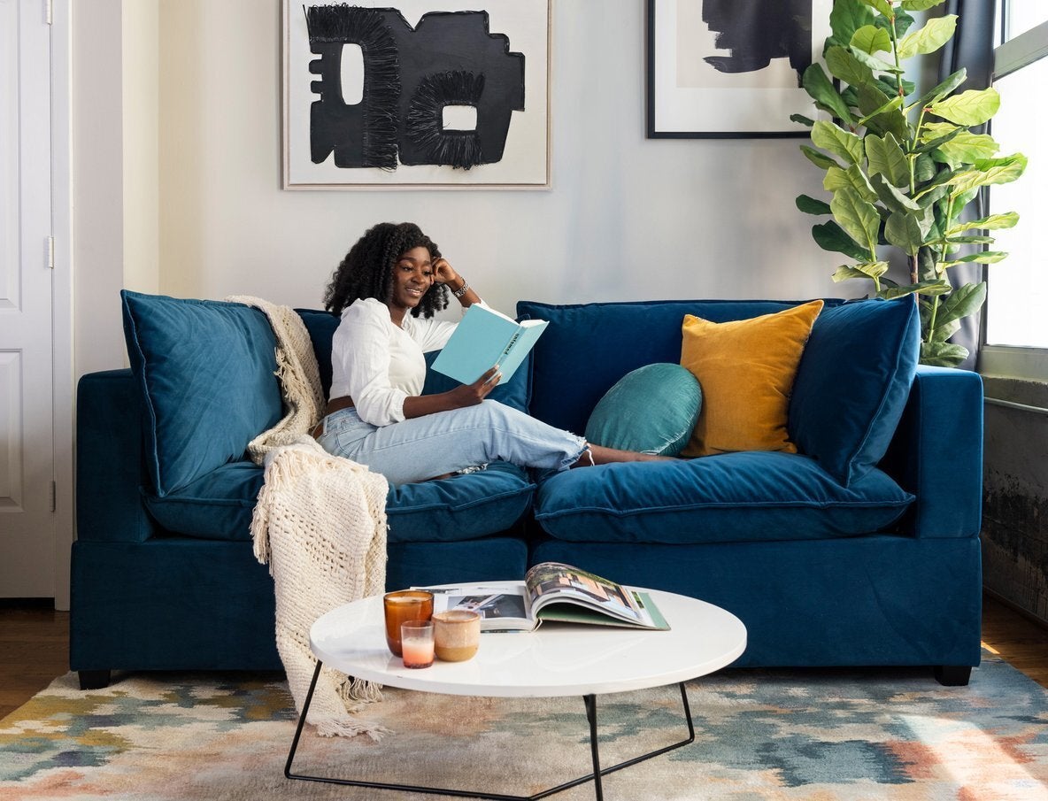 two piece sofa with mirrored sides and several plush pillows making up the seats, sides, and back