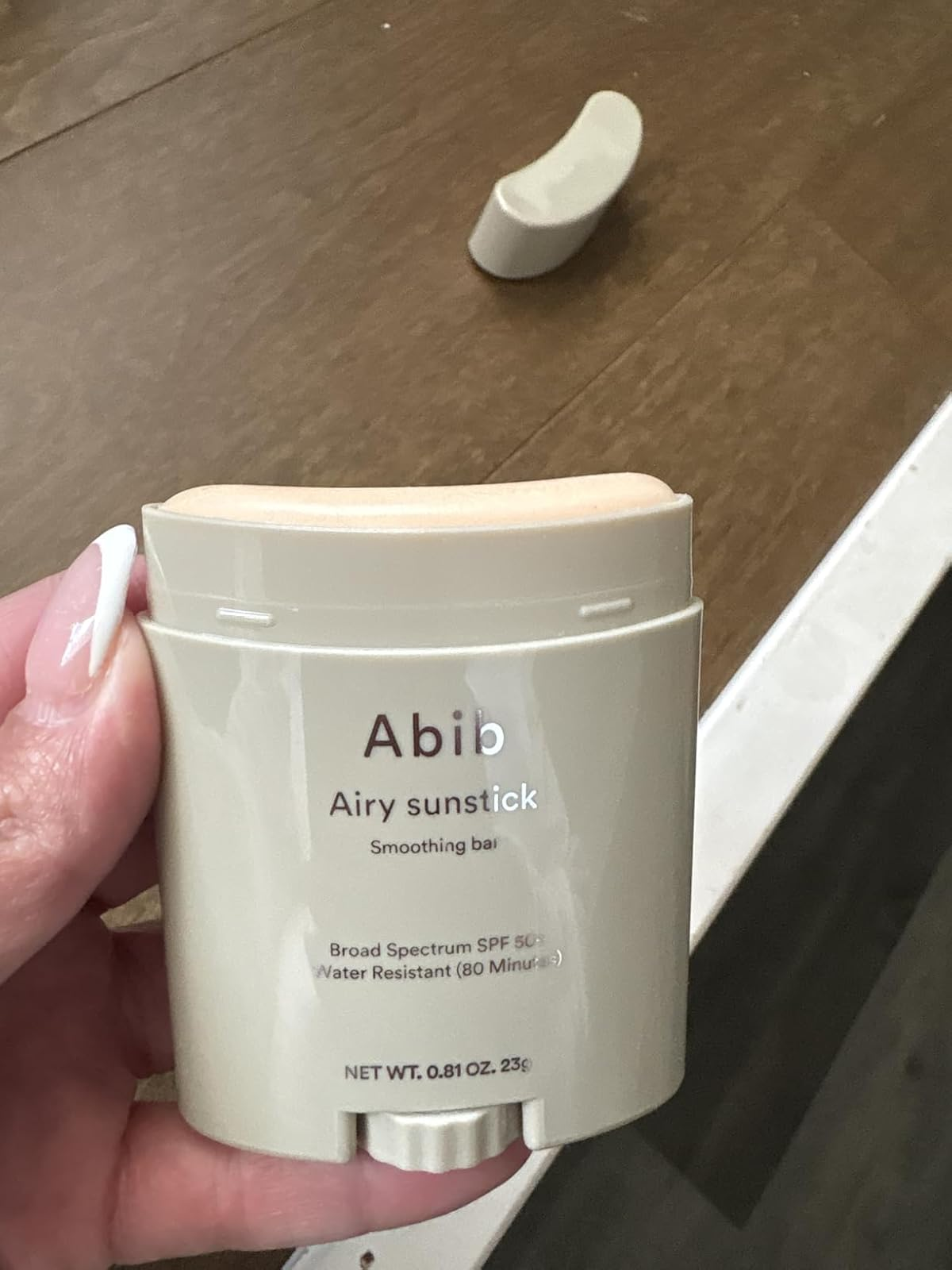 Hand holding an Abib Airy Sunstick Smoothing Bar, SPF 50+, water-resistant for 80 minutes