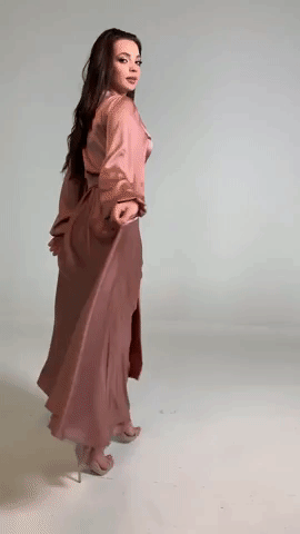 Model walking in long sleeve maxi rose gold dress