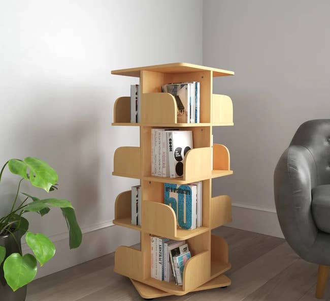 the light wooden geometric revolving bookshelf full of books