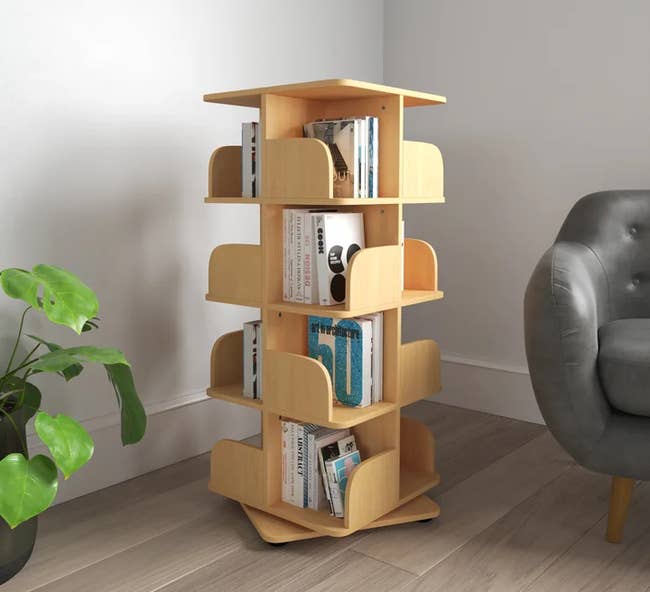 the light wooden geometric revolving bookshelf full of books