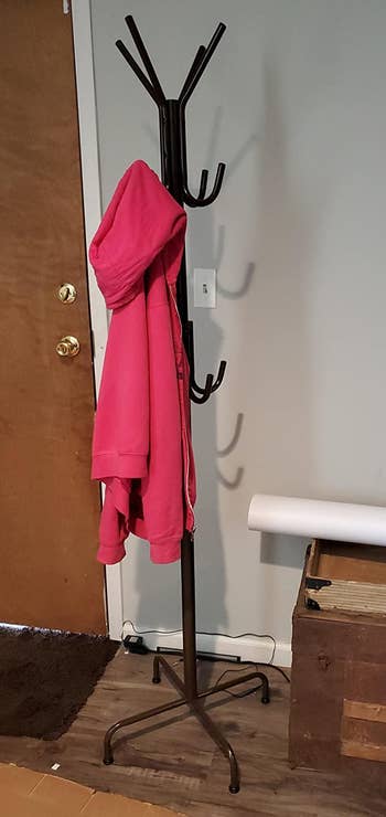 Reviewer image of black coat rack with red jacket